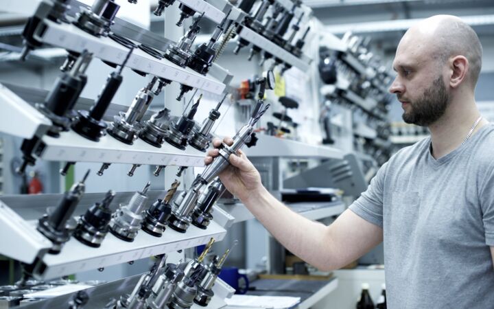 Mitarbeiter entnimmt Werkzeug aus dem Vorhaltelager der Maschine